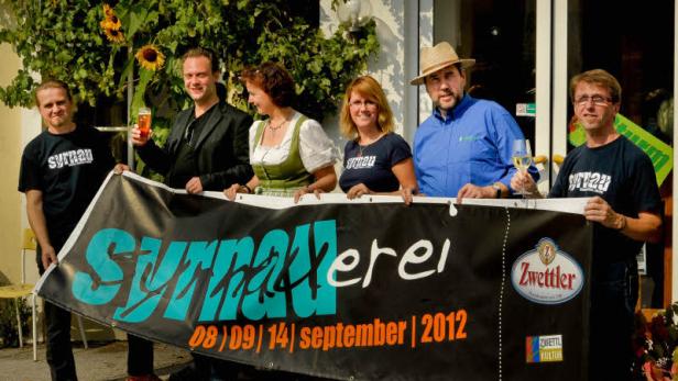 Eine Gruppe von Personen hält ein Banner der Syrnauer Biererei aus dem Jahr 2012.