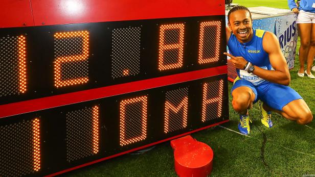 Ein Sprinter kniet neben einer Anzeigetafel mit der Aufschrift 12,80 und 110 MH.