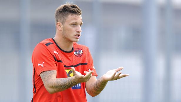 Ein Fußballspieler im roten Trikot der österreichischen Nationalmannschaft gestikuliert.