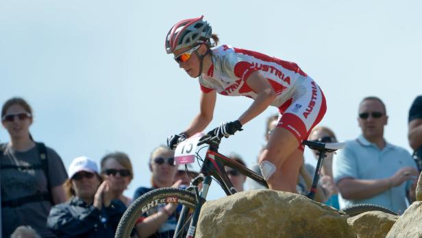 Eine Mountainbikerin aus Österreich fährt über einen steinigen Abschnitt.