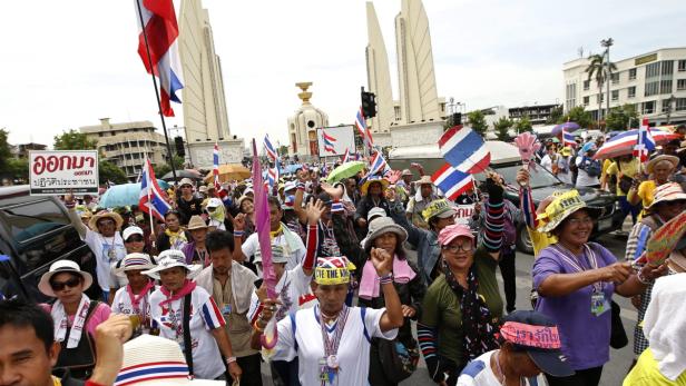 Eine Menschenmenge demonstriert mit thailändischen Flaggen vor dem Demokratie-Denkmal in Bangkok.