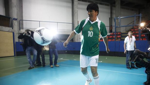 Evo Morales jongliert mit einem Fußball vor einer Gruppe von Fotografen.