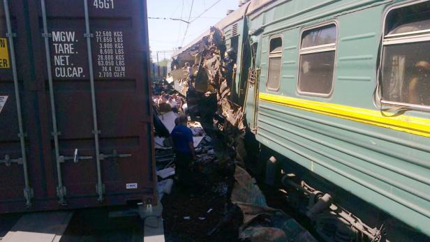 Ein Zugunglück mit einem beschädigten Personenzug und einem Güterwaggon.