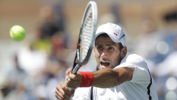 Novak Đoković schlägt einen Tennisball während eines Spiels.