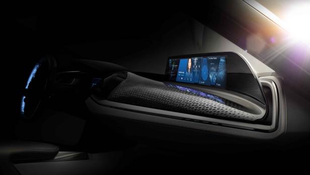 Das futuristische Armaturenbrett eines Autos mit einem großen, gebogenen Bildschirm.