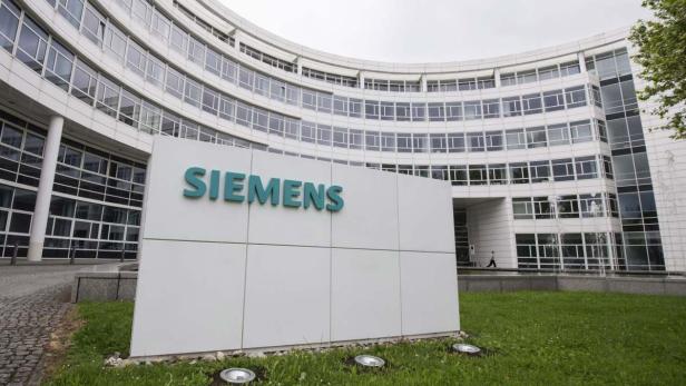 Das Siemens-Logo vor einem modernen Bürogebäude.
