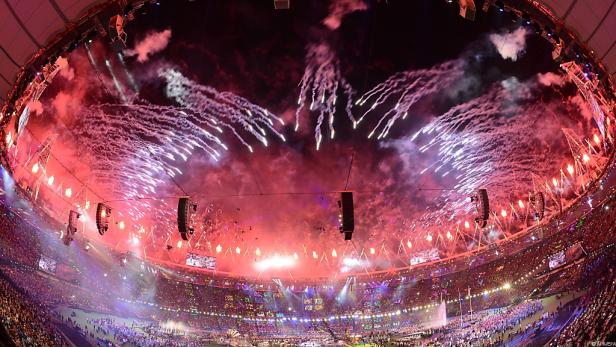 Feuerwerk erhellt ein vollbesetztes Stadion bei einer Veranstaltung.