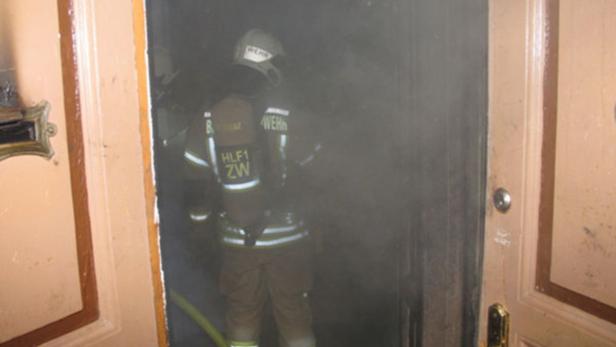 Ein Feuerwehrmann betritt ein verrauchtes Gebäude.