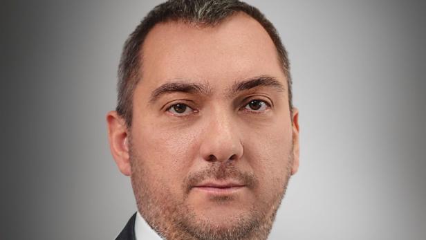 Porträt eines Mannes mit braunen Augen und kurzem, dunklem Haar.