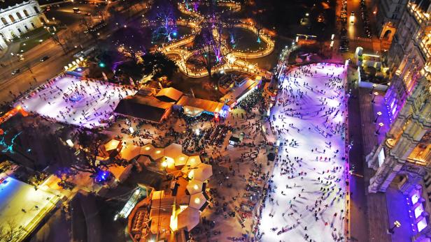 Luftaufnahme des Wiener Eistraums mit vielen Menschen auf den Eisflächen.