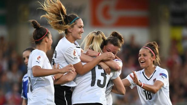 Österreichische Fußballspielerinnen feiern gemeinsam auf dem Spielfeld.