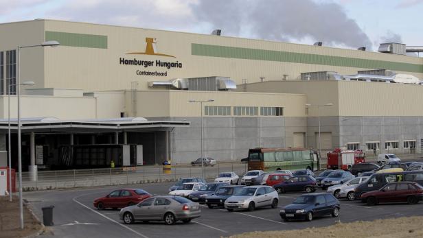 Das Hamburger Hungaria Containerboard Werk mit Parkplatz und einigen Fahrzeugen.
