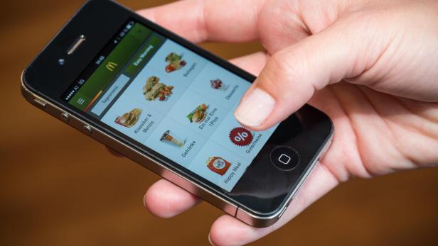 Eine Hand bedient die McDonald's App auf einem iPhone.
