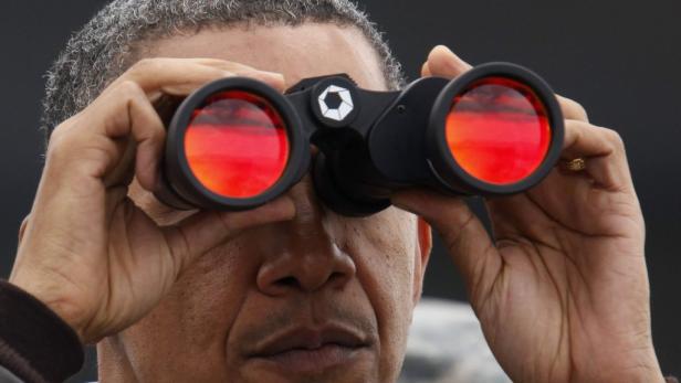 Barack Obama blickt durch ein Fernglas.