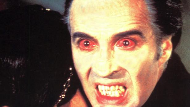 Christopher Lee als Graf Dracula mit roten Augen und spitzen Zähnen.