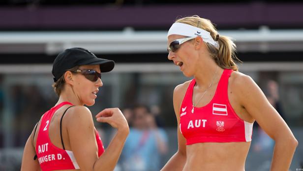 Zwei österreichische Beachvolleyballspielerinnen unterhalten sich am Spielfeldrand.