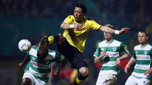 Ein Fußballspieler in Gelb tritt einem anderen Spieler gegen den Kopf.
