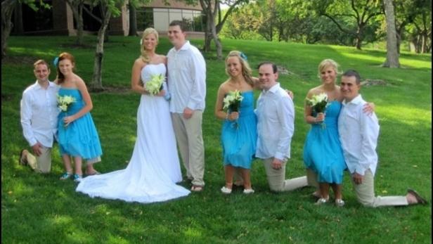 Eine Hochzeitsgesellschaft posiert auf einer Wiese für ein Gruppenfoto.