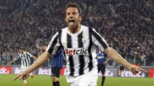 Ein Fußballspieler von Juventus Turin jubelt mit ausgestreckten Armen und herausgestreckter Zunge.