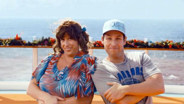 Adam Sandler posiert mit sich selbst in Frauenkleidern auf einem Kreuzfahrtschiff.