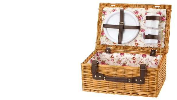 Ein geöffneter Picknickkorb mit Geschirr und floralem Innenfutter.