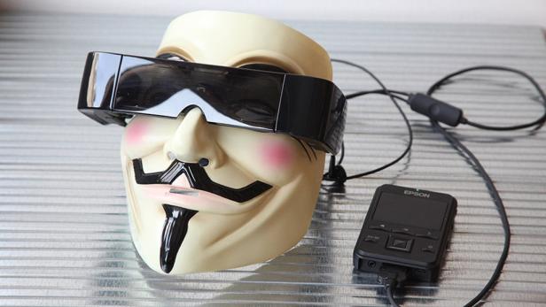 Eine Guy-Fawkes-Maske trägt eine Epson Moverio Brille.