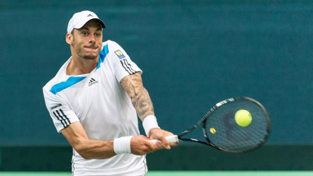 Ein Tennisspieler schlägt einen Ball mit seinem Schläger.