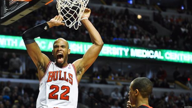 Ein Basketballspieler der Chicago Bulls dunkt den Ball und jubelt.