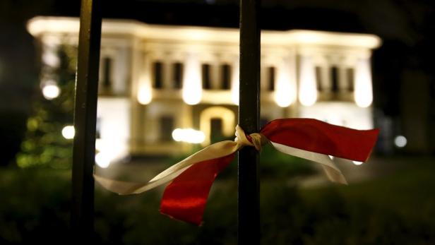 A ribbon is seen attached to a fence in front of t Polens Regierung holt ihre eisernen Besen hervor