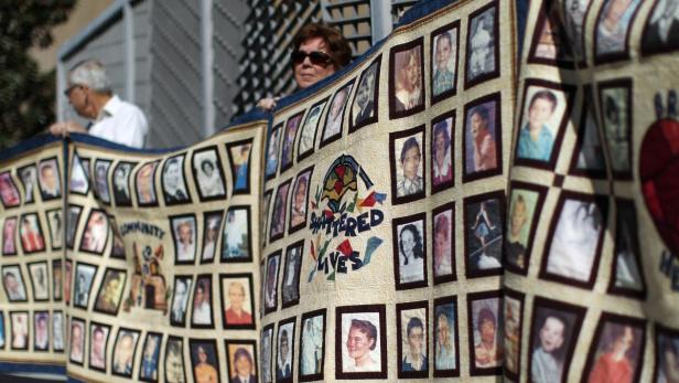 Mitglieder einer Selbsthilfeorganisation vor einer katholischen Kirche in Los Angeles. Die Quilts zeigen Fotos von Missbrauchsopfern