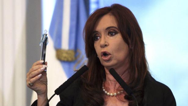 Cristina Fernández de Kirchner hält einen Stift mit argentinischen Farben in die Höhe.