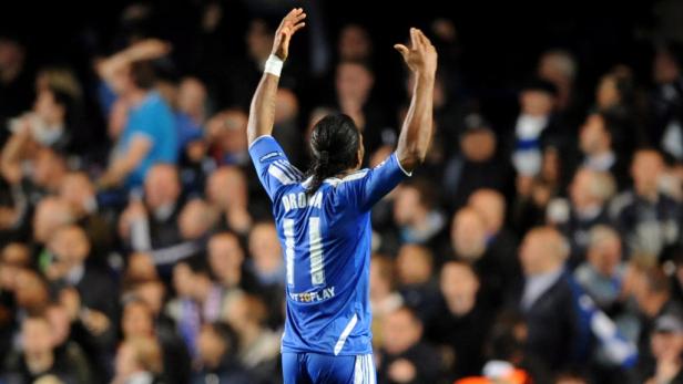 Didier Drogba jubelt mit erhobenen Armen vor einer Zuschauermenge.