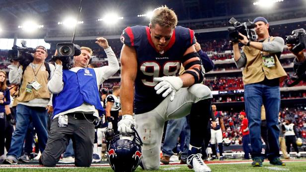 Ein Footballspieler der Houston Texans kniet auf dem Spielfeld, umringt von Fotografen.
