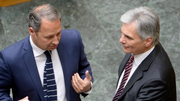 Zwei Männer in Anzügen unterhalten sich.