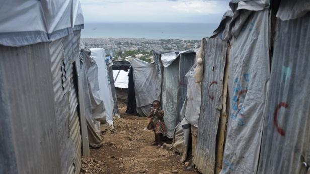 A Haitian girl stands in a tent camp for people affected by the 2010 earthquake, outside Port-au-Prince August 24, 2012. An estimated 400,000 Haitians affected by the quake are living in precarious tents. Tropical Storm Isaac passed the Dominican Republic and headed toward Haiti on Friday, rumbling slowly west across the Caribbean after unleashing heavy rain on parts of Puerto Rico. REUTERS/Swoan Parker (HAITI - Tags: DISASTER ENVIRONMENT TPX IMAGES OF THE DAY)