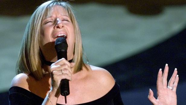 Barbra Streisand singt mit geschlossenen Augen in ein Mikrofon.