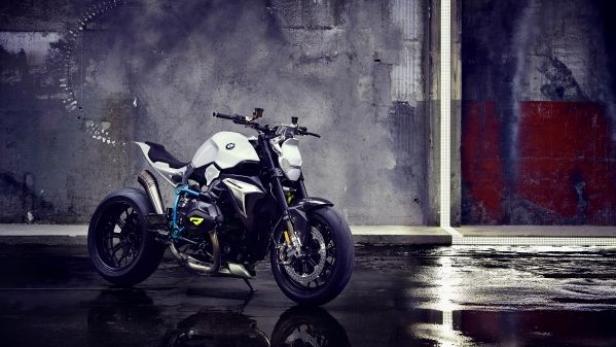 Ein schwarzes und weißes BMW-Motorrad steht vor einer Betonwand.