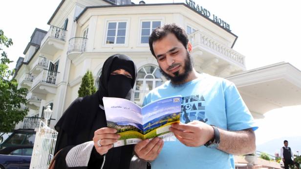 Nora und Alharbi Mohammad aus Saudi Arabien mit der Broschüre „Where Cultures Meet“. Über manche Tipps müssen sie schmunzeln.