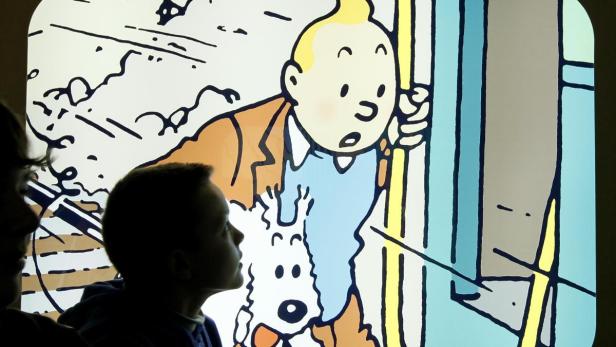 Kinder betrachten eine Illustration von Tim und Struppi.