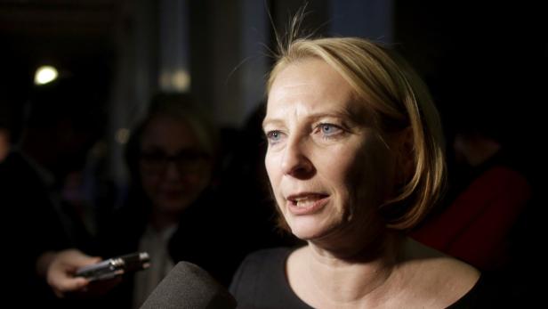Eine blonde Frau spricht in ein Mikrofon.