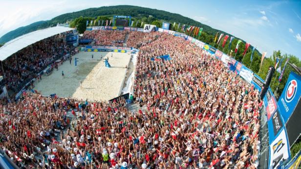 Ein Beachvolleyballspiel mit einer großen Menschenmenge im Publikum.