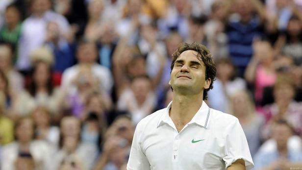 Roger Federer blickt mit geschlossenen Augen und einem Lächeln ins Publikum.