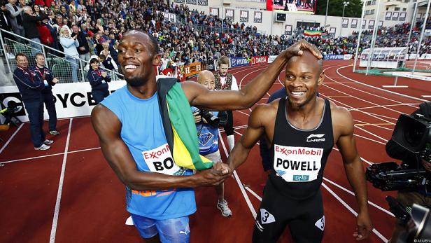 Usain Bolt gratuliert Asafa Powell auf der Laufbahn.