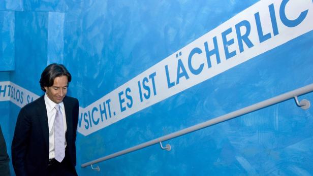 Ein Mann in Anzug geht eine Treppe mit der Aufschrift „Aussicht. Es ist lächerlich“ hinunter.