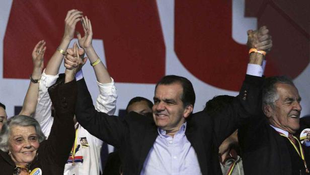 Enthusiastische Menschen jubeln mit erhobenen Händen auf einer politischen Veranstaltung.