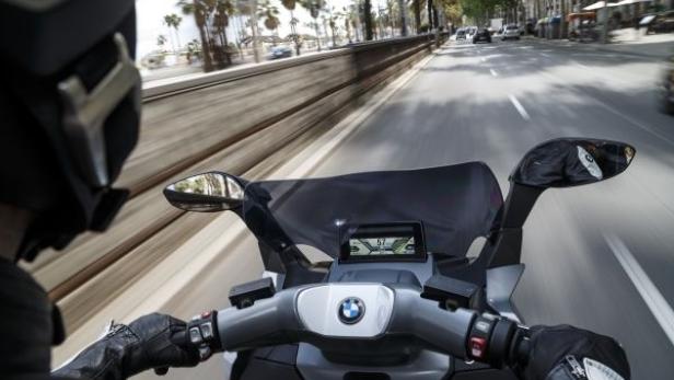 Ein Motorradfahrer fährt auf einer Straße mit Palmen in Barcelona.
