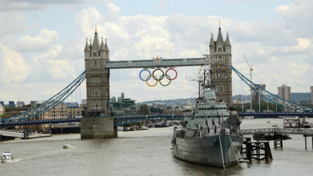 Die Tower Bridge in London mit den olympischen Ringen und einem Schiff davor.