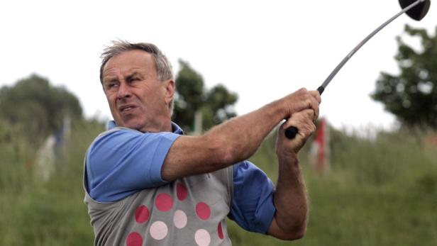 Ein Mann schwingt einen Golfschläger auf einem Golfplatz.