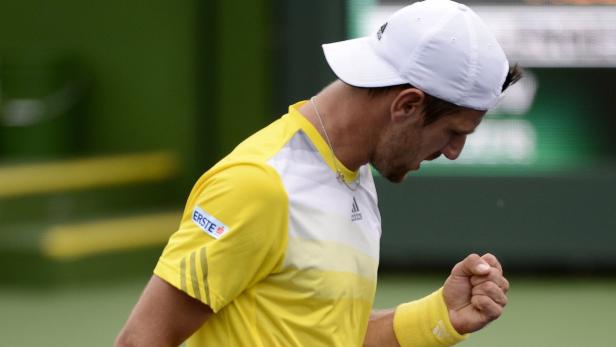 Ein Tennisspieler in gelbem Hemd ballt die Faust.