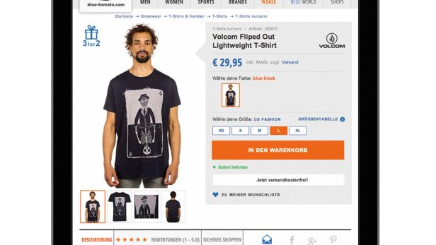 Ein Mann präsentiert ein Volcom T-Shirt auf der Blue Tomato Webseite.